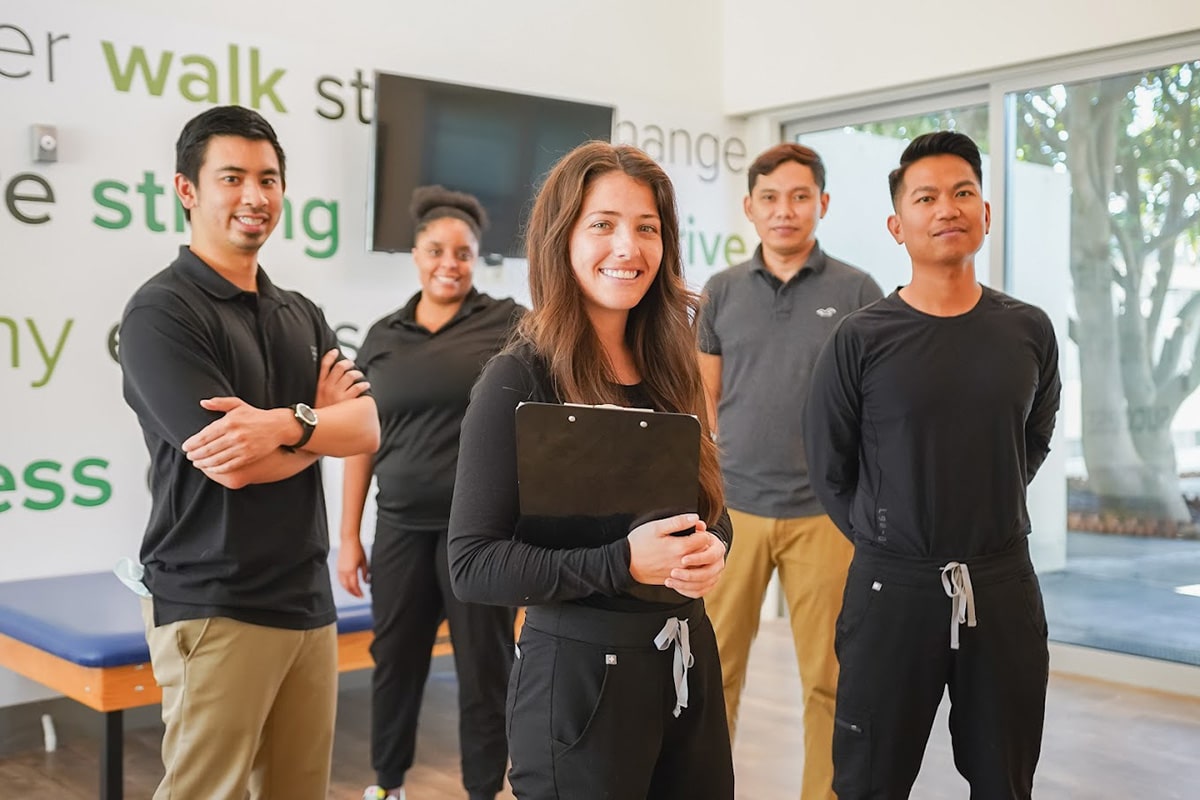 Several caregivers standing in the rehab gym at Central Gardens Post Acute