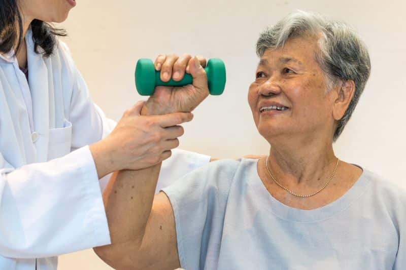 PACS-300x200-rehab2 physical therapist working with patient holding dumbbell